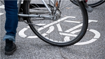 Ein Fahrradfahrer steht auf der Straße auf einem Fahrradpiktogramm.
