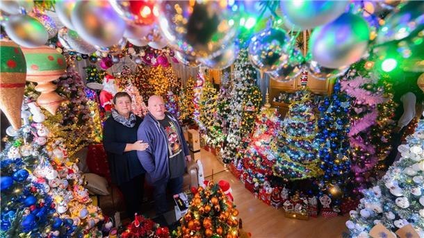 Rekord: Paar stellt 555 Weihnachtsbäume zu Hause auf Mehr Weihnachten geht kaum: Susanne und Thomas Jeromin stehen inmitten von Weihnachtsbäumen im Wohnzimmer ihres Hauses.
