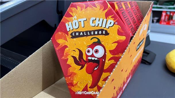 Mehrerer Packungen der „Hot Chip Challenge“ in einem Späti neben der Kasse.