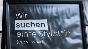 Mehrgeschlechtliche Suche nach Personal auf einem Schild in Berlin.
