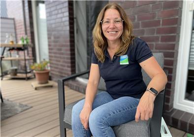 Frau mit Brille, die auf der Terrasse auf einem Stuhl sitzt. Melanie Schmidt, Tourismus-Service Butjadingen