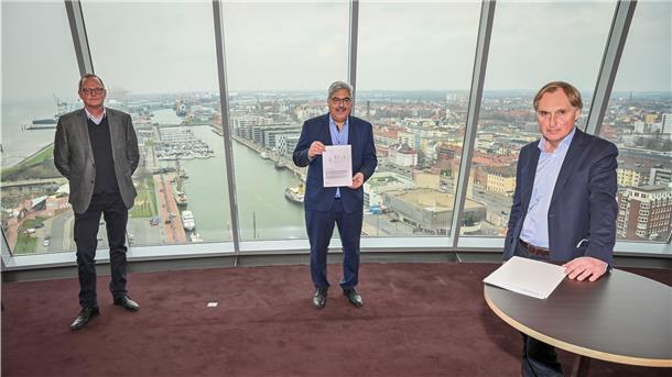 Melf Grantz (Mitte) mit dem „Bremerhavener Memorandum“ der Bundesstiftung Baukultur, überreicht von deren Vorstandsvorsitzenden Reiner Nagel (rechts). Mit der Umsetzung der darin enthaltenen zehn Handlungsempfehlungen wird auch Nils Schnorrenberger (links), der Geschäftsführer der Bremerhavener Bremerhavener Gesellschaft für Investitionsförderung und Stadtentwicklung zu tun haben.