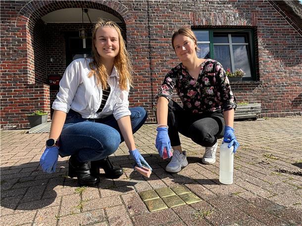 Stolpersteine in Loxstedt: Azubis setzen Zeichen gegen das Vergessen Zwei junge Frauen hocken am Boden. Vor ihnen sechs kleine Messingplatten – die Stolpersteine.