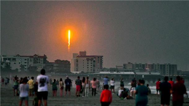Menschen beobachten am Cocoa Beach im US-Bundesstaat Florida, wie die SpaceX-Rakete in Cape Canaveral abhebt.
