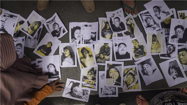 Mindestens 174 Tote bei Massenpanik in Indonesien Menschen, die nach ihren Angehörigen suchen, betrachten Fotos von Opfern der Fußballkrawalle, die ihnen von Freiwilligen zur Verfügung gestellt wurden, um ihnen bei der Identifizierung ihrer Familienangehörigen zu helfen.
