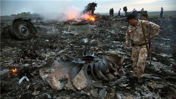 Menschen gehen im Juli 2014 durch die Trümmer an der Absturzstelle des Passagierflugzeugs MH17 in der Nähe des Dorfes Grabovo in der Ostukraine.