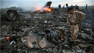 Menschen gehen im Juli 2014 durch die Trümmer an der Absturzstelle des Passagierflugzeugs MH17 in der Nähe des Dorfes Grabovo in der Ostukraine.