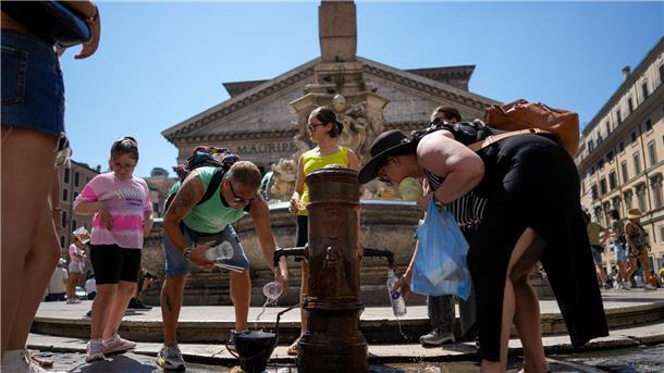 Hitze in Italien - Höchste Alarmstufe in 16 größeren Städten Menschen kühlen sich an einem Springbrunnen vor dem Pantheon in Rom ab.