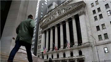 Menschen passieren die Fassade der New Yorker Börse.