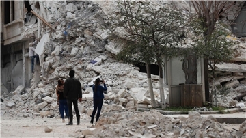 Menschen stehen vor den Trümmern eines Gebäudes, das bei dem jüngsten Erdbeben in Aleppo zerstört wurde.