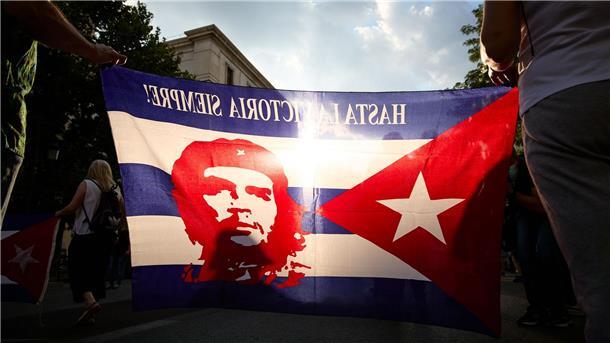Ungeplante Ikone: Berühmtes Che-Porträt wird 65 Menschen tragen eine Fahne mit einer Abbildung des legendären Ernesto Che Guevara während einer Kundgebung zur Unterstützung der kubanischen Regierung.