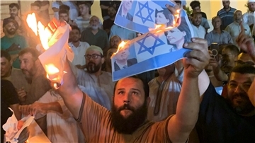 Menschen verbrennen in Tripolis Bilder, die den israelischen Außenminister Eli Cohen und seine libysche Amtskollegin Nadschla al-Mankusch zeigen.