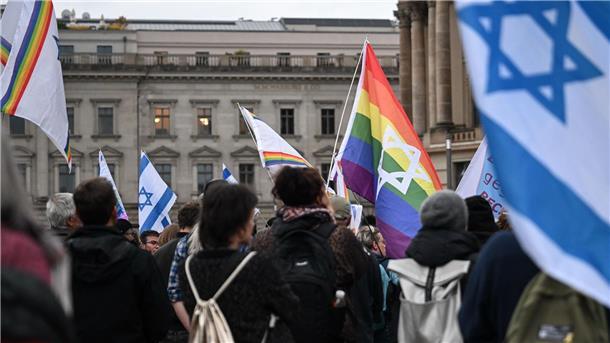 Brandenburger Tor zum Gedenken an 7. Oktober angestrahlt Menschen versammeln sich auf dem Bebelplatz zu einer Mahnwache zum 7. Oktober 2023.
