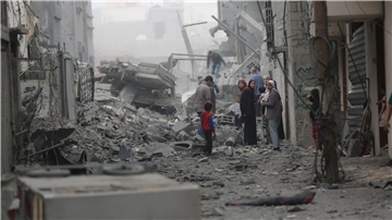 Menschen versammeln sich auf den Trümmern eines zerstörten Gebäudes nach einem Luftangriff im Flüchtlingslager Maghazi im Zentrum des Gazastreifens.