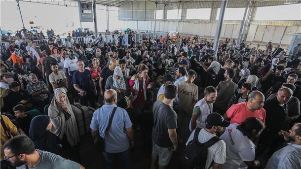 Menschen warten am Grenzübergang zwischen dem Gazastreifen und Ägypten.
