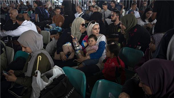 Menschen warten am Grenzübergang zwischen dem Gazastreifen und Ägypten.