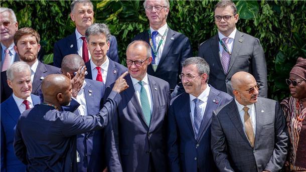 Merz stellt sich zum Familienfoto auf der COP30 auf.