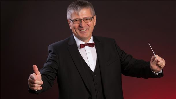 Michael Ruf dirigiert mit einem Taktstock.