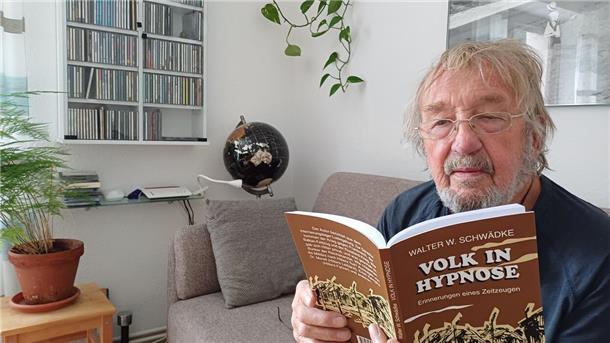 Michael Schwädke aus Schiffdorf hält ein Buch in der Hand.