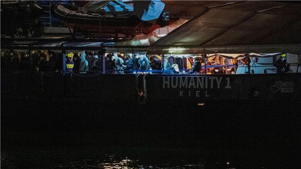 Lage auf Rettungsschiffen: Menschen springen ins Wasser Migranten stehen an Deck der „Humanity 1“ im Hafen von Catania.