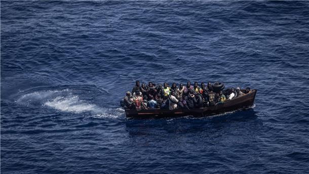 Tausende Bootsmigranten erreichen Lampedusa: Lager überfüllt Migranten steuern ein Boot in Richtung der Insel Lampedusa.