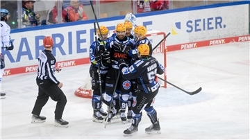 Eine schwarze Jubeltraube von Eishockeyspielern. Die Fischtown Pinguins aus Bremerhaven bejubeln ein Tor.