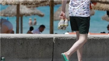 Mit Bier unterwegs -  am Strand von Arenal auf Mallorca.