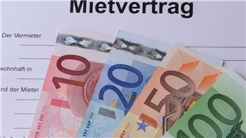 Geldscheine liegen auf einem Muster-Mietvertrag