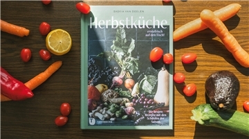 Das Buch "Herbstküche – erntefrisch auf den Tisch", umgeben von Gemüse.