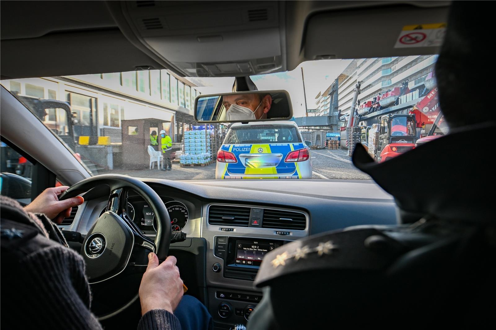 Mit dem Polizeiauto fahren die Beamten von einem Frachtschiff zum Columbus Cruis...