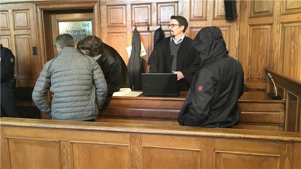 Schlag ins Gesicht eines Polizisten? Goethestraße-Prozess beginnt mit Streit Männer stehen rückwärts auf der Anklagebank.