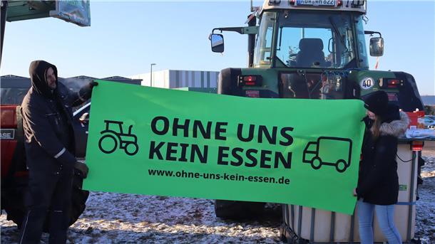 Mit der Aufschrift von diesem Banner wollen die Landwirte vor dem Rewe-Zentrallager in Sottrum ein Zeichen setzen.
