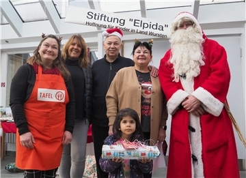 Mit der kleinen Jasmina freuen sich (von links) Ulrike Grünhagen (Leiterin der Dorumer Tafel ), Susanne Weinrich (im Elpida Vorstand), das Ehepaar Sabine und Dimitrios Aggelidis sowie der Weihnachtsmann über die vorweihnachtliche Bescherung.