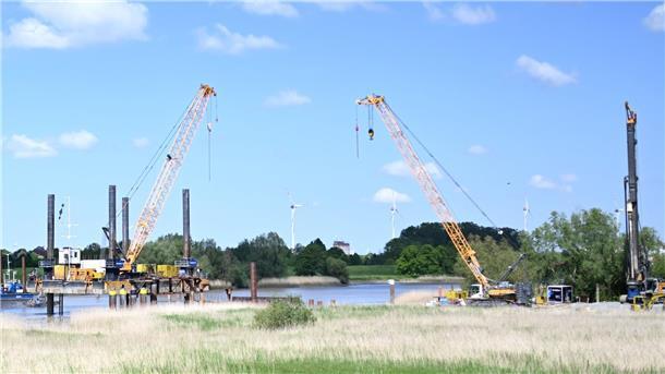 Über einen Fluss wird eine neue Eisenbahnbrücke errichtet.
