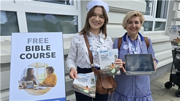 Zwei Frauen in maritimer Bekleidung neben einem Aufsteller