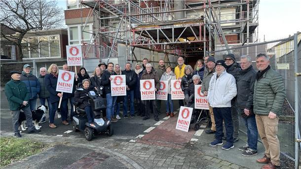 Bürger mit Protestschildern vor dem Rathausturm in Nordenham.