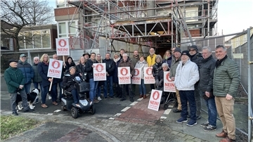 Bürger mit Protestschildern vor dem Rathausturm in Nordenham.