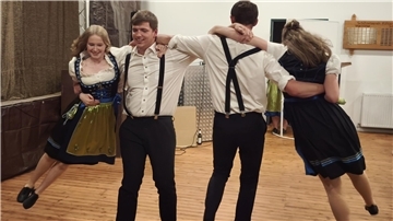 Zwei Männer und zwei Frauen tanzen.