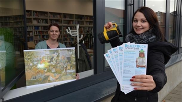 Mit Taschenlampe geht’s auf Bildersuche in den Schaufenstern: Susanne Austein, Leiterin der Stadtbücherei (links), und Mitarbeiterin Ronja Rozbach freuen sich auf den Bilderbuch-Spaziergang durch Langen und Bad Bederkesa.