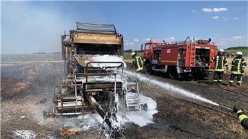 Mit vereinten Kräften gegen den Brand: Einsatzkräfte aus Midlum und Wanhöden löschen das Feuer, das eine Rundballenpresse und weite Ackerflächen in Midlum entzündet hat.