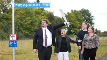 Mit viel Schwung enthüllt Wolfgang Neumanns Witwe Christa Neumann gemeinsam mit ihren Kindern Lars (links), Birte und Kai den Straßennamen im Dorumer Neubaugebiet an der Robert-Wiebalck-Straße, mit dem die Gemeinde das Wirken ihres Mannes und Vaters in Land Wursten würdigt.