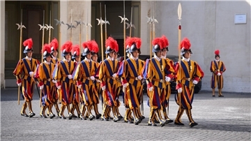 Mitglieder der Schweizergarde tragen ihre Uniform, die in den Farben Blau-Rot-Gelb gestreift ist.