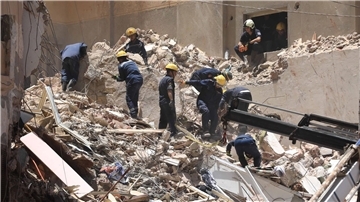 Mitglieder des ägyptischen Zivilschutzes bei den Überresten des eingestürzten 13-stöckigen Wohngebäudes in Alexandria.
