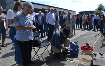 Mitte Juni 2022 in der Mückenburg in Zeven: Unter großer Anteilnahme der Bevölkerung verlegt Gunter Demnig Stolpersteine im Gedenken der Familie Wolff. Carla Lucka hält ein Foto ihrer ermordeten Großmutter Klara Wolff in Händen und verfolgt unter Tränen die Verlegung.