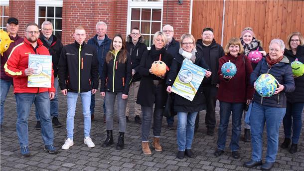 Mitwirkende des geplanten Entdeckertages vor der Markthalle in Rodenkirchen. Sie zeigen Kugelfische, die Stadlander Kinder im vergangenen Jahr gebastelt hatten.