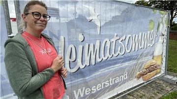 Es ist die Veranstalterin Mitzi Brunke zu sehen. Zusammen mit ihrem Mann Klaus stellt sie den Heimatsommer auf die Beine.  