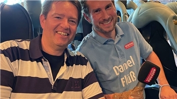 Moderator Daniel Flüß hat sich sein Mikro mit Tape an die Hand geklebt, damit es ihm während der Schussfahrt mit Axel Linneweber nicht aus der Hand gerissen wird.