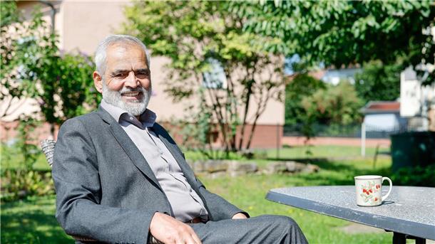 Mohammed Tarik aus Afghanistan sitzt im Garten seines Mietshauses. Er lebt seit Oktober 2022 mit seiner Frau und zwei Töchtern in einem Dorf bei Bamberg (Bayern).