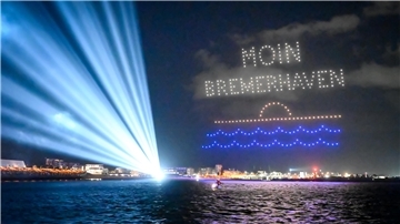 Drohnen schreiben auf der Sail 2025 "Moin Bremerhaven" in den Nachthimmel.
