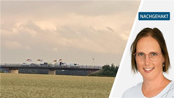 Autos mit Deutschland-Fahnen auf einer Autobahnbrücke